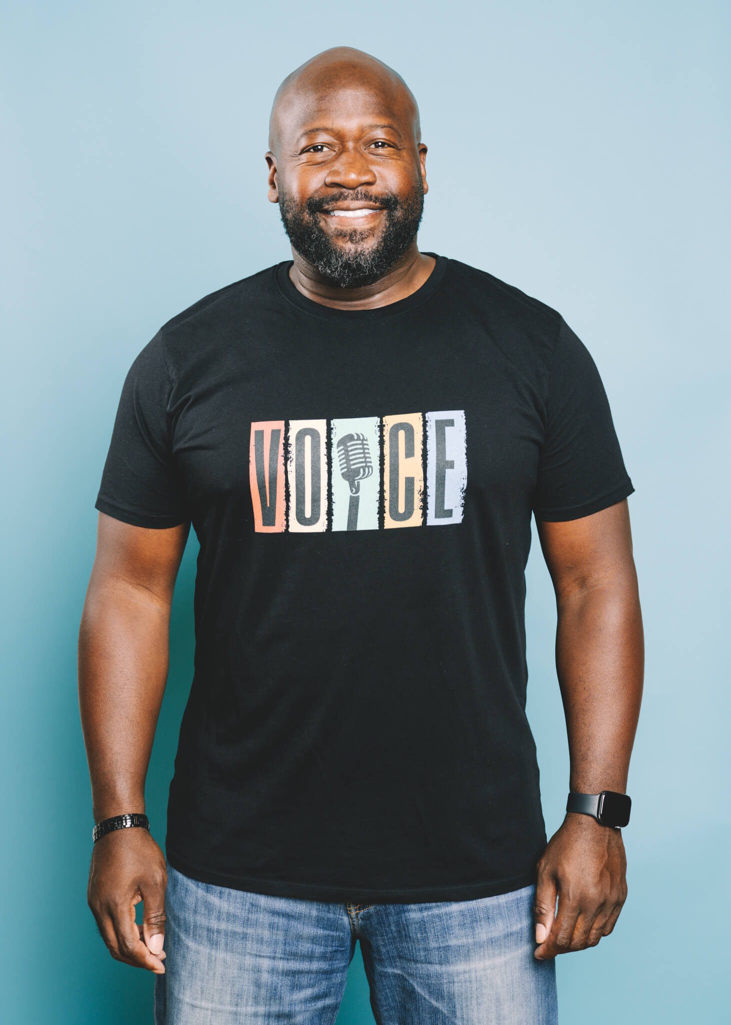 Man in a Black Shirt In Front of a Light Blue Background